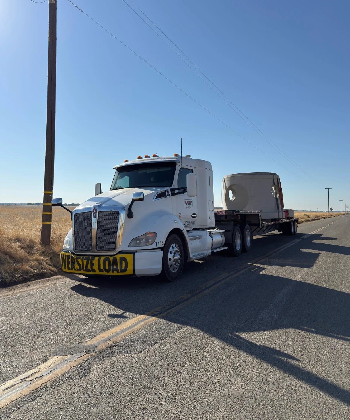 Velazquez Bros truck running an oversize load on a rural highway