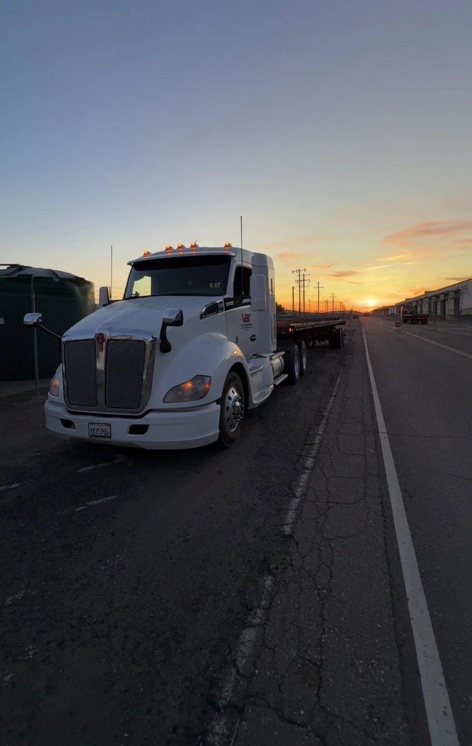 Velazquez Bros tractor and flatbed at sunset